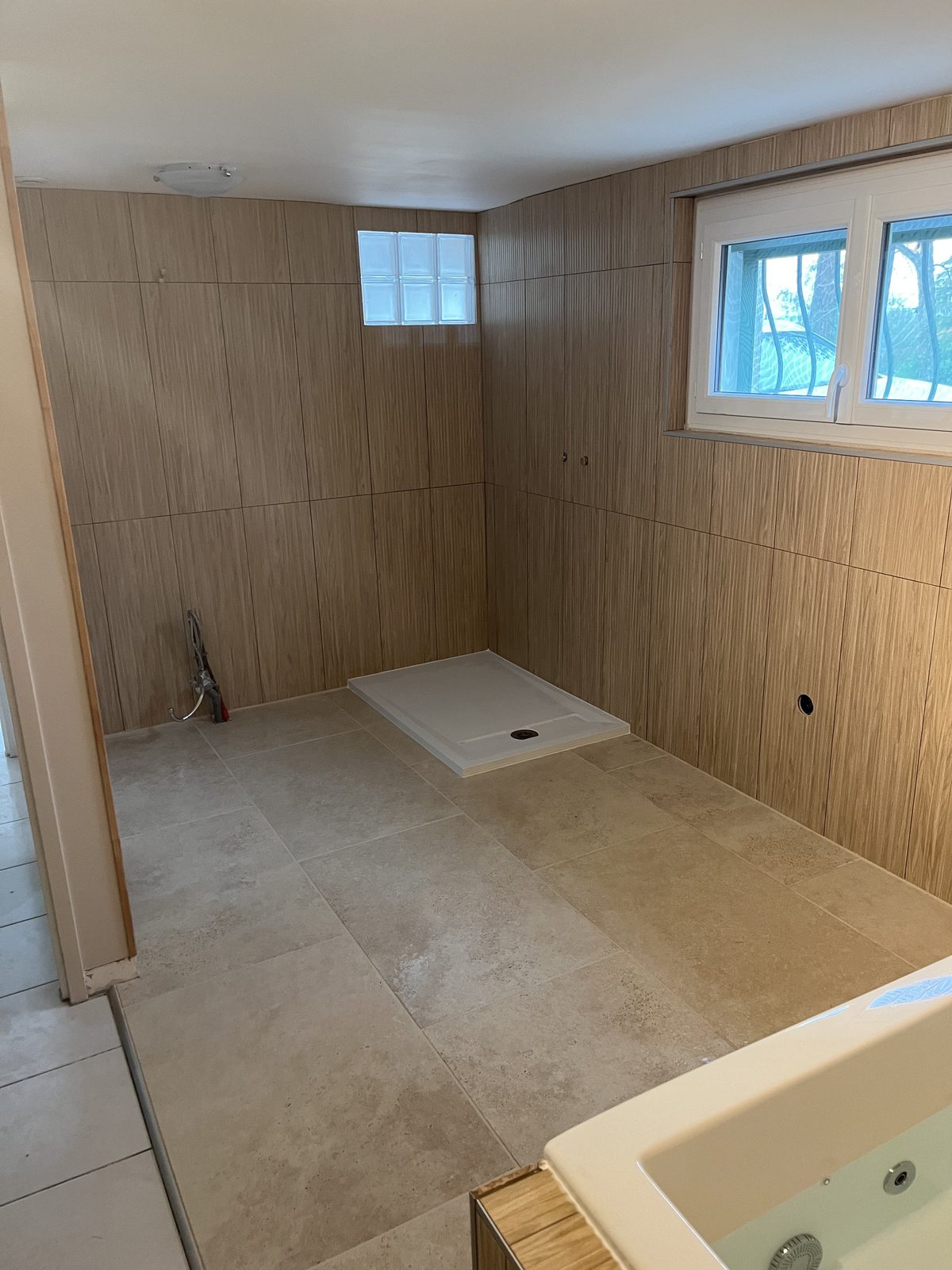 Pose de carrelage effet travertin dans une salle d'eau dans le Tarn par TNR Carrelage
