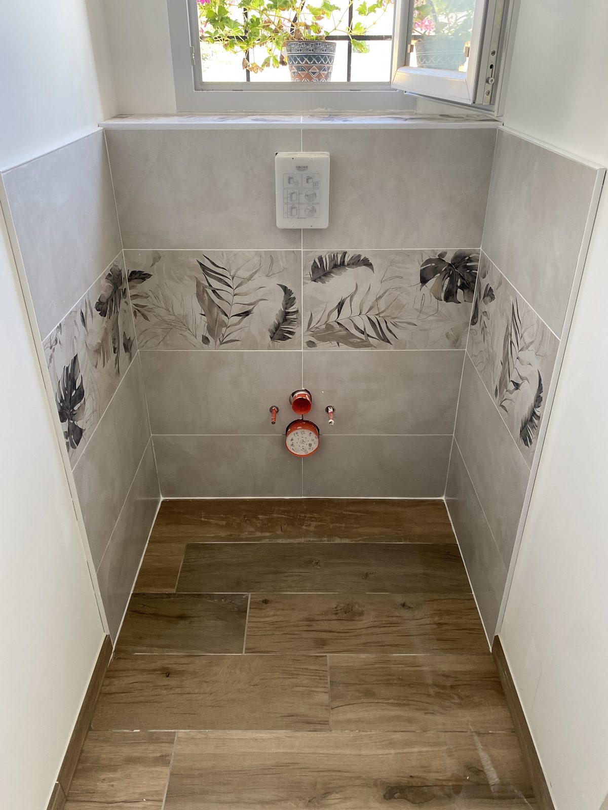 WC avec frise de carrelage à motif végétal et sol effet bois à Castres par TNR Carrelage