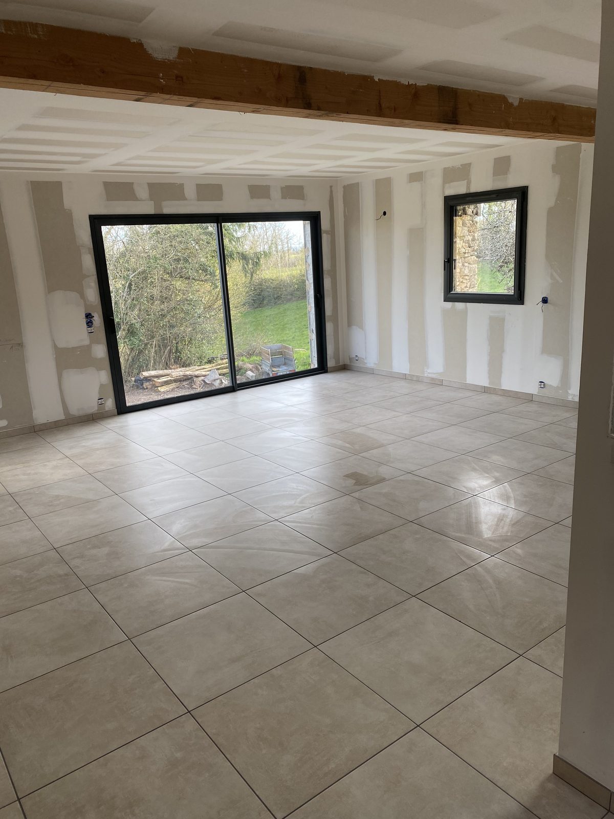 Carrelage grand format gris posé dans un séjour avec baie vitrée à Castres par TNR Carrelage