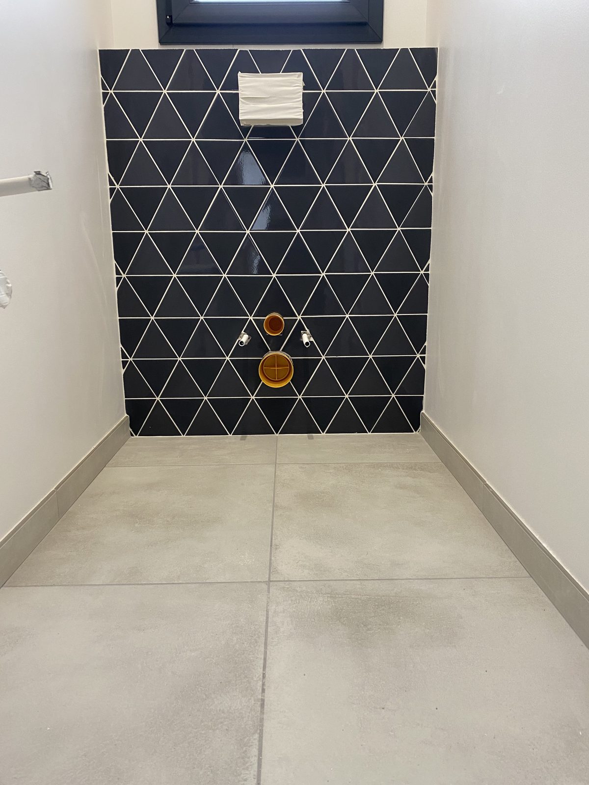 Revêtement mural en mosaïque triangulaire bleu nuit dans une salle de bain dans le Tarn par TNR Carrelage